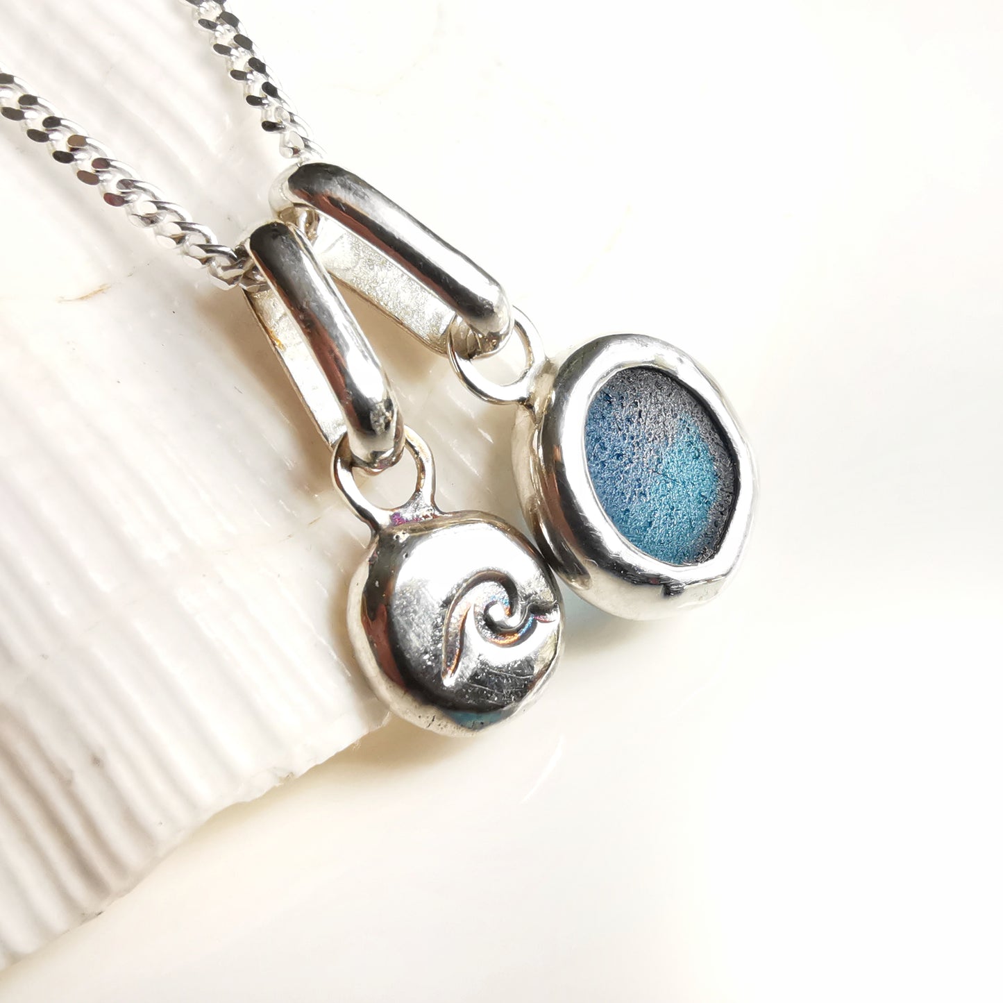 Tiny Scottish teal blue sea glass and wave pebble duo of sterling silver pendants.
