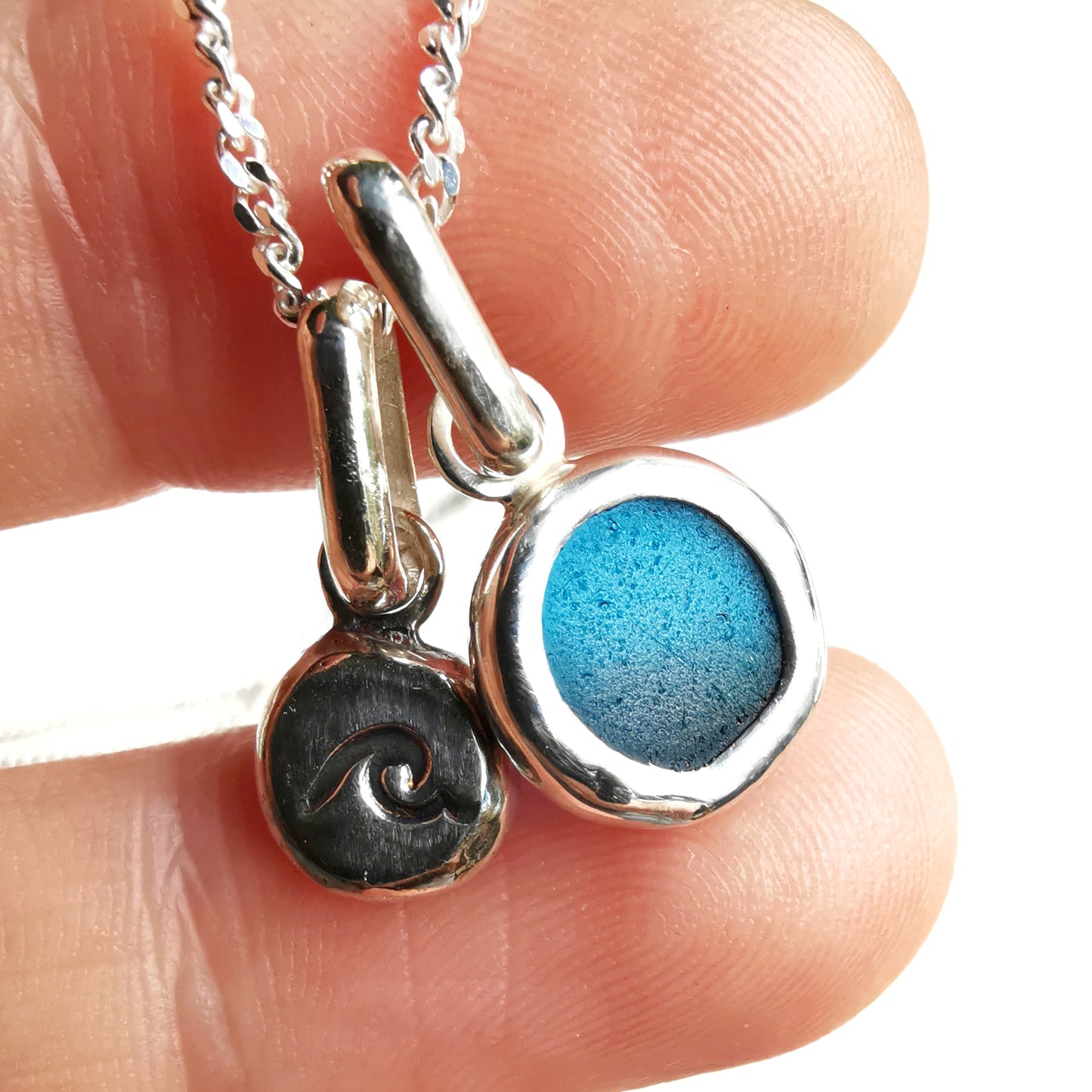 Tiny Scottish teal blue sea glass and wave pebble duo of sterling silver pendants.