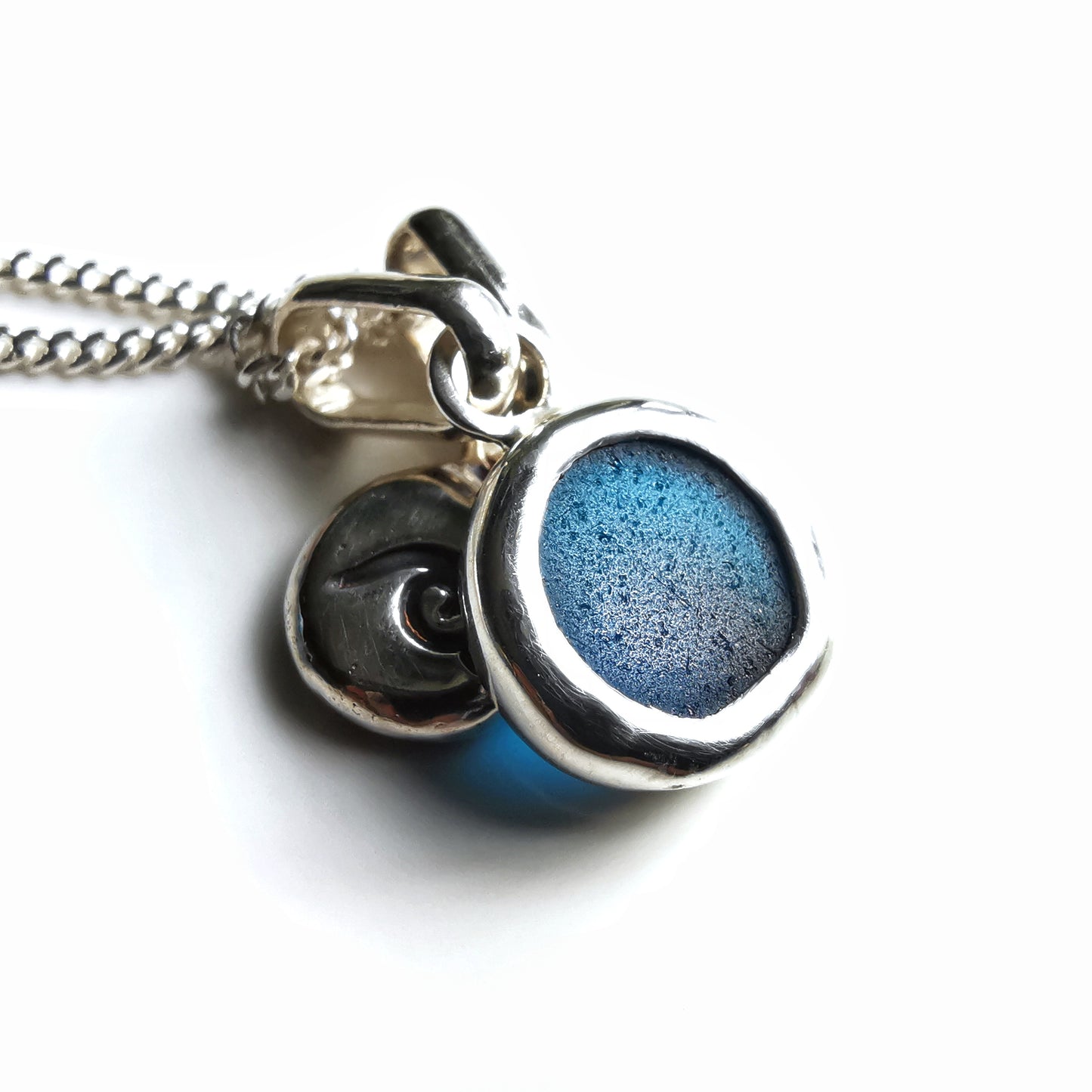 Tiny Scottish teal blue sea glass and wave pebble duo of sterling silver pendants.