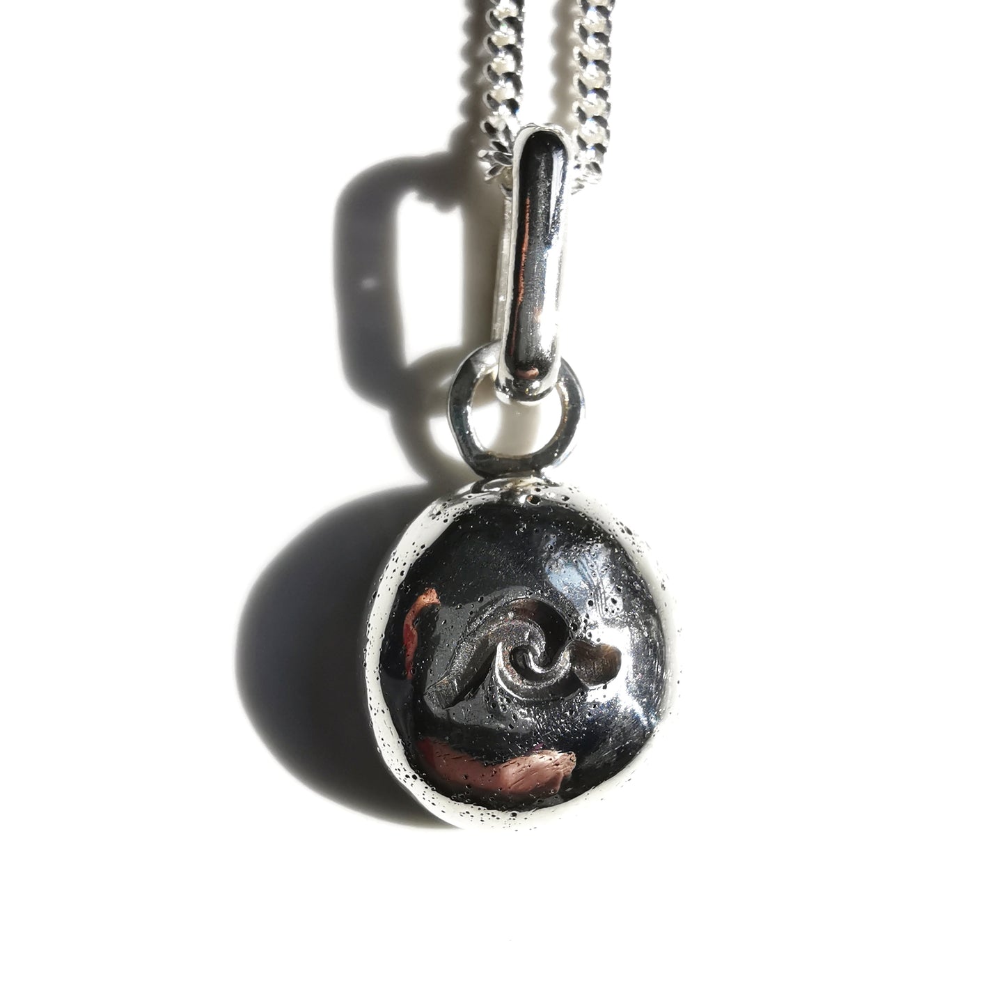 Sterling silver wave pebble pendant.