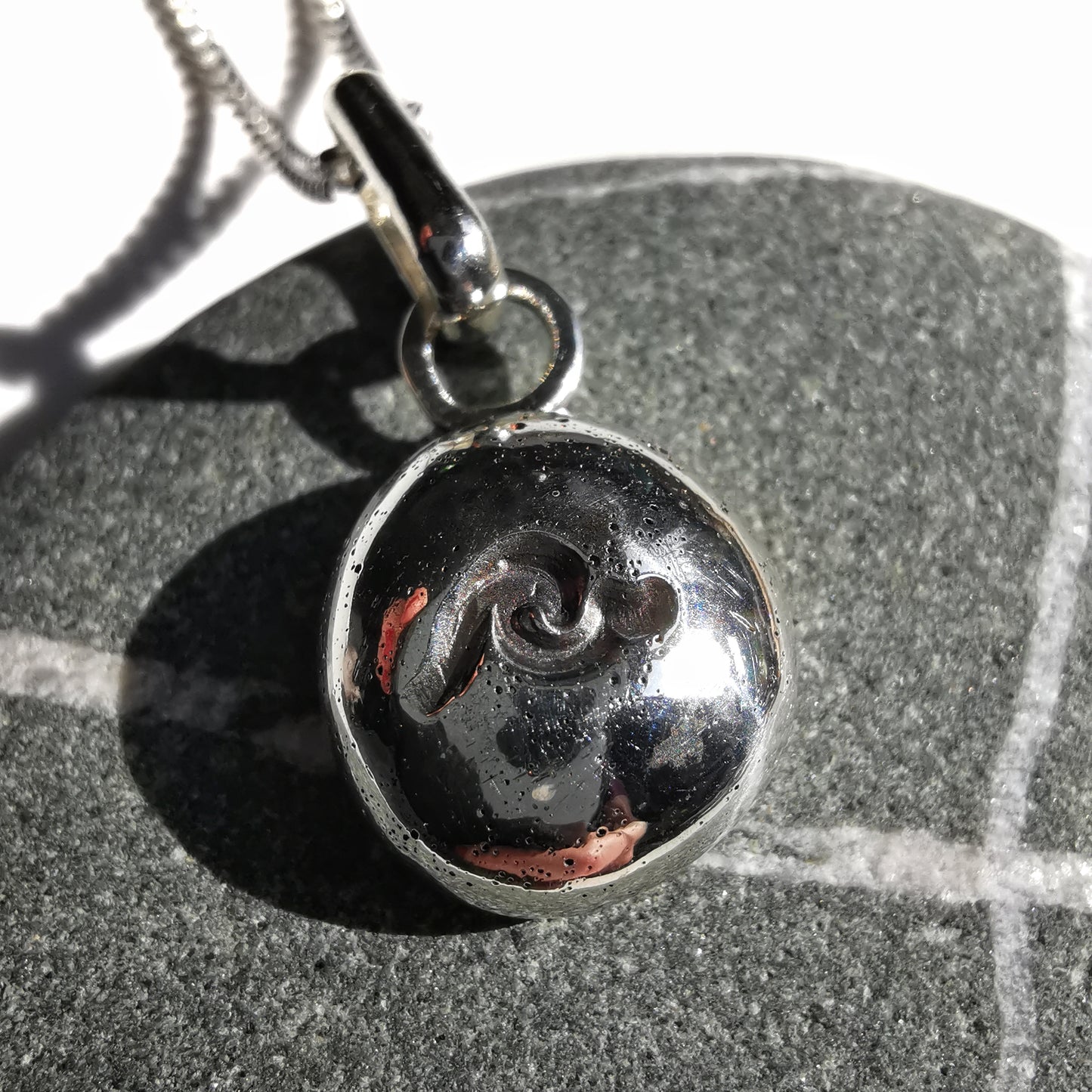 Sterling silver wave pebble pendant.