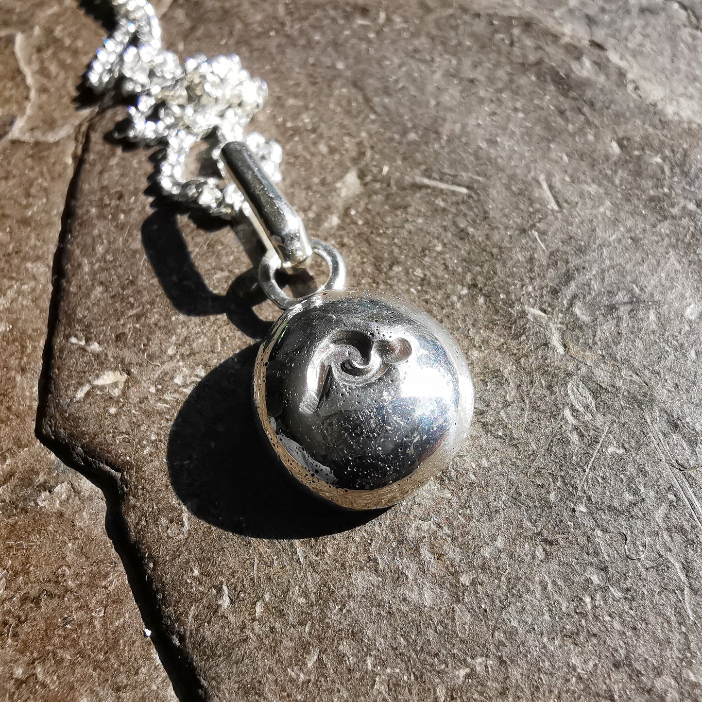 Sterling silver wave pebble pendant.