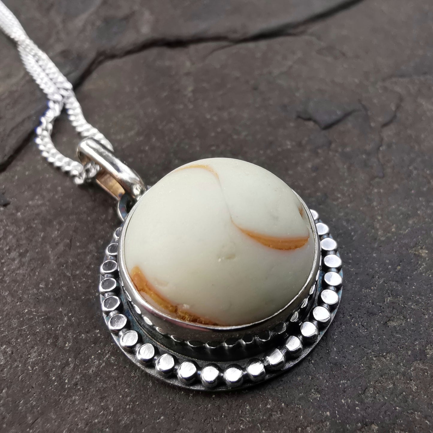 Scottish off white UV partial sea glass marble & sterling silver pendant.