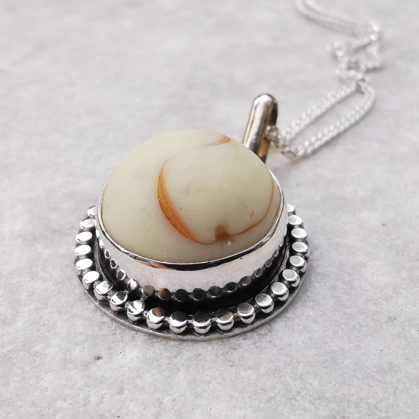 Scottish off white UV partial sea glass marble & sterling silver pendant.