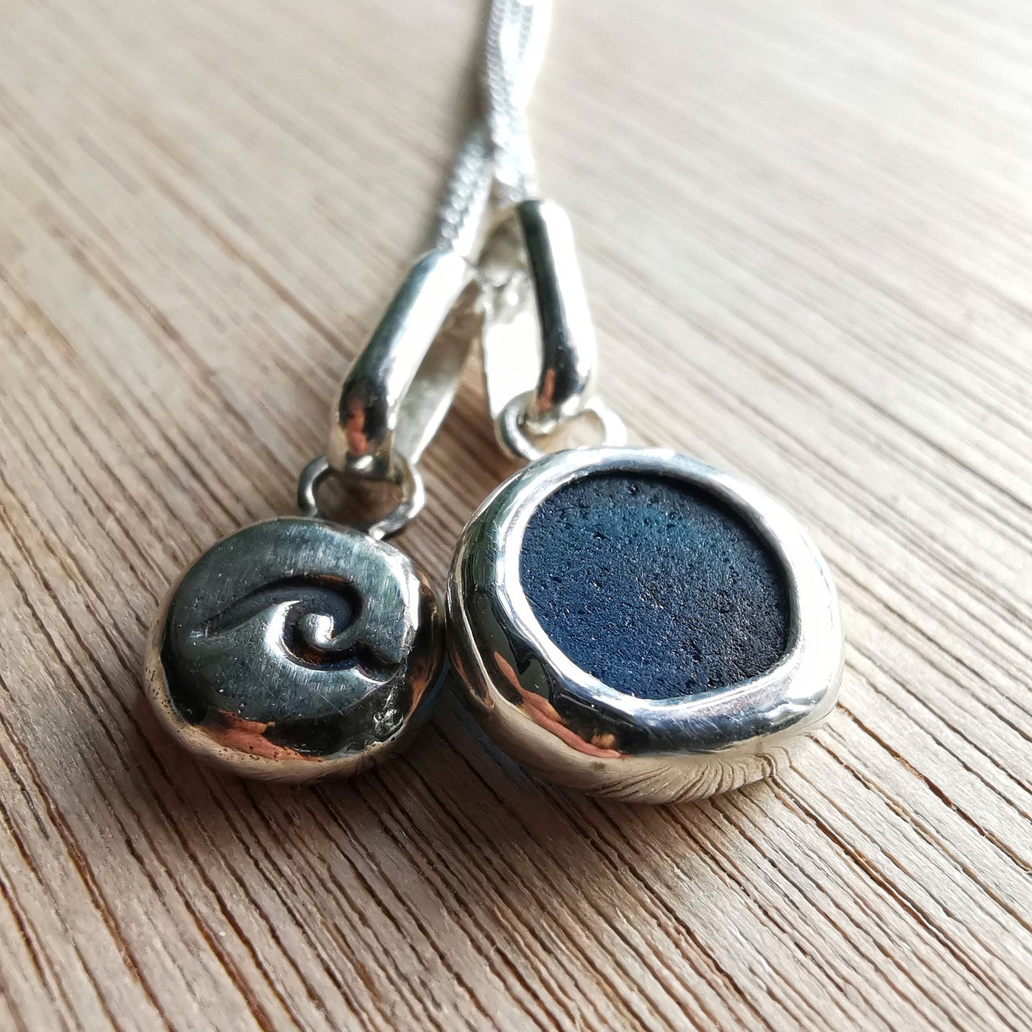 Tiny Scottish teal blue sea glass and wave pebble duo of sterling silver pendants.