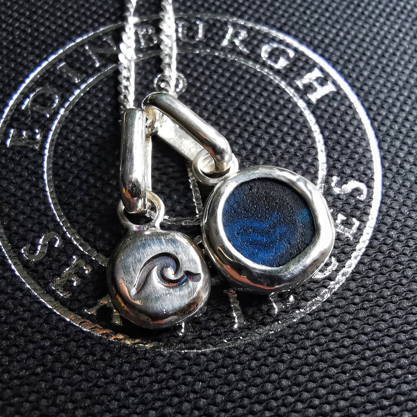Tiny Scottish teal blue sea glass and wave pebble duo of sterling silver pendants.
