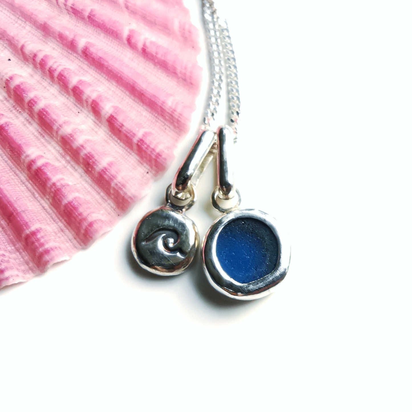 Tiny Scottish teal blue sea glass and wave pebble duo of sterling silver pendants.