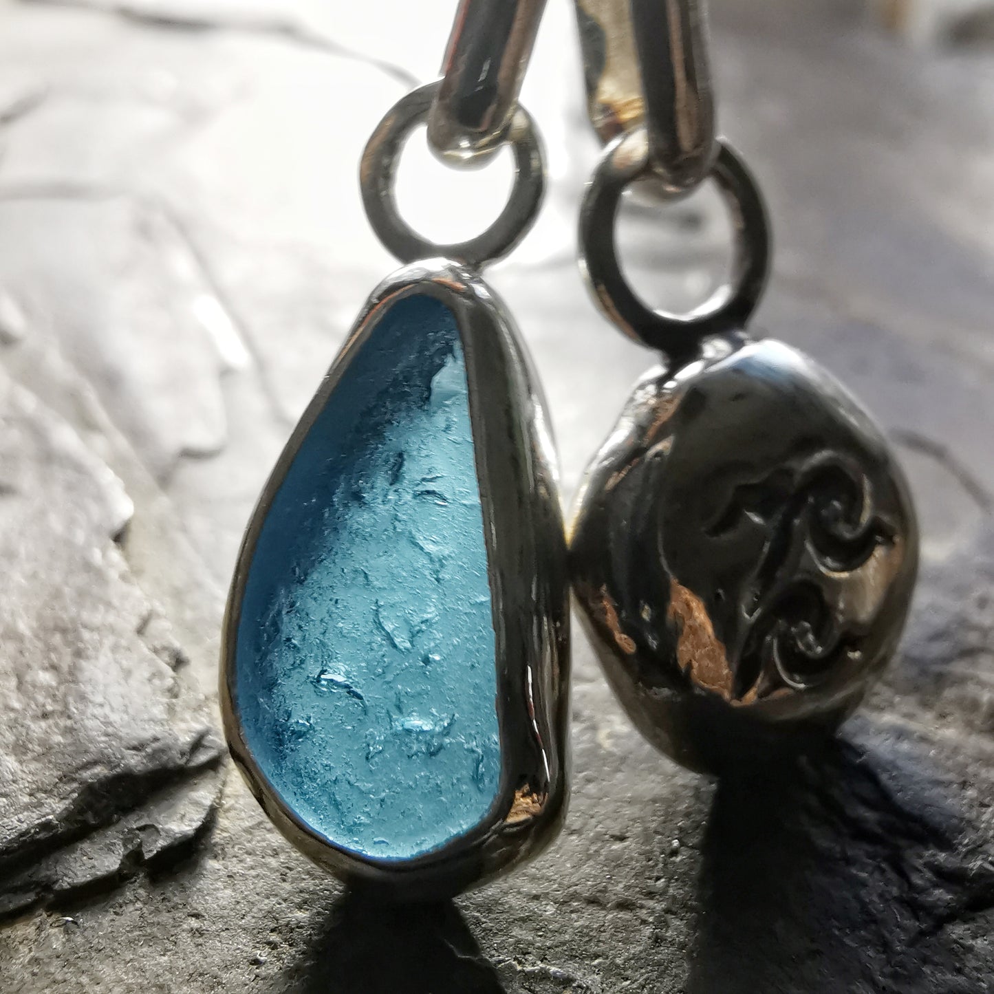 Blue sea glass and silver wave pebble duo of pendants.