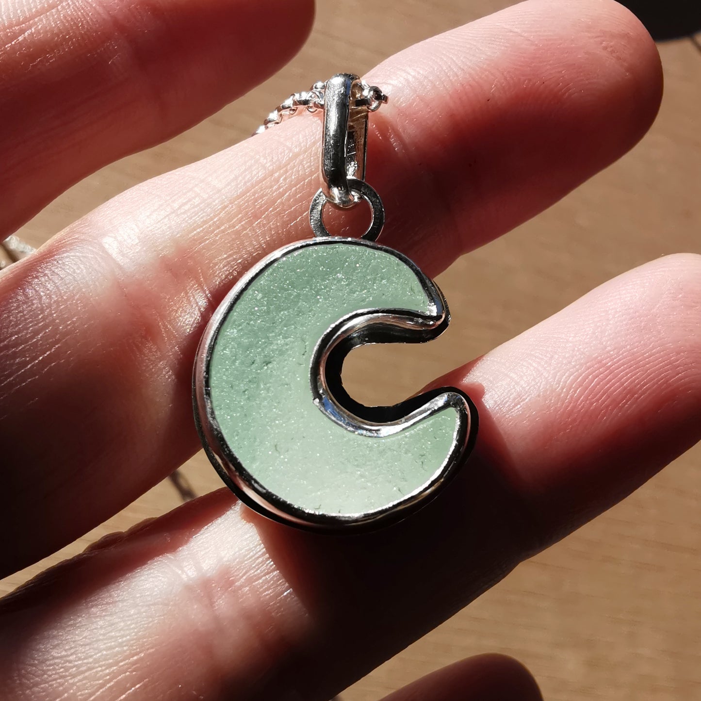 Opalescent crescent moon sea glass & sterling silver pendant.