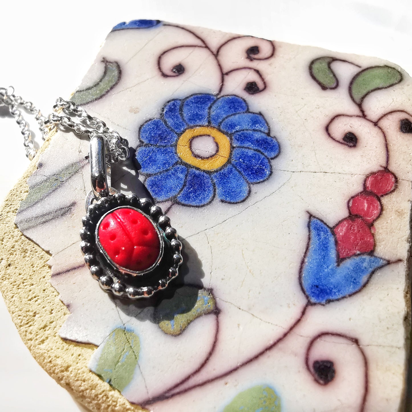 Tiny red sea glass ladybird & sterling silver pendant.