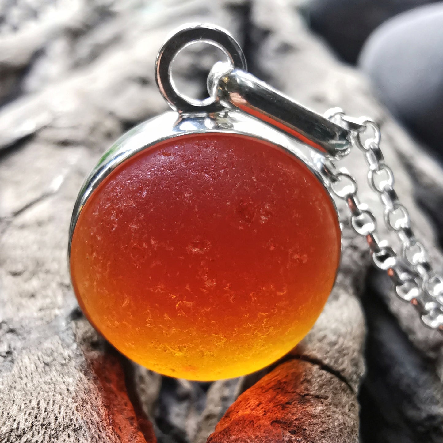 Genuine orange UV sea glass marble & sterling silver pendant.