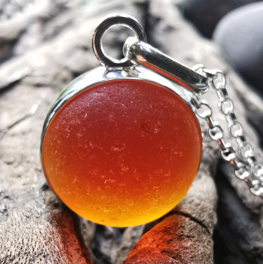 Genuine orange UV sea glass marble & sterling silver pendant.
