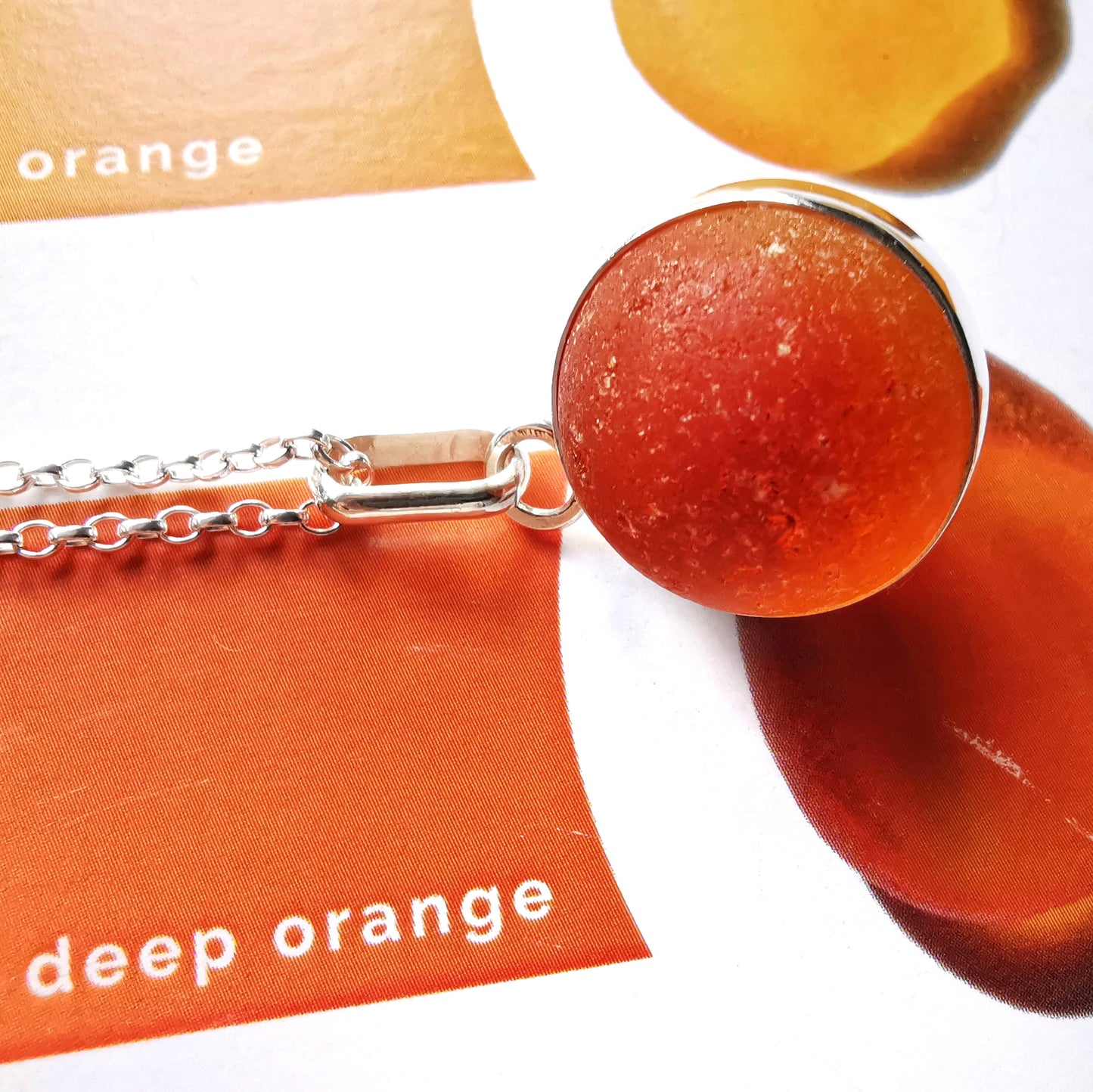 Genuine orange UV sea glass marble & sterling silver pendant.