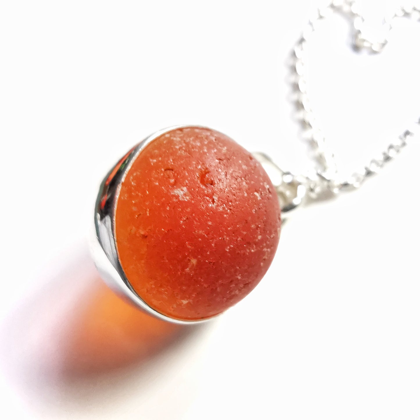 Genuine orange UV sea glass marble & sterling silver pendant.