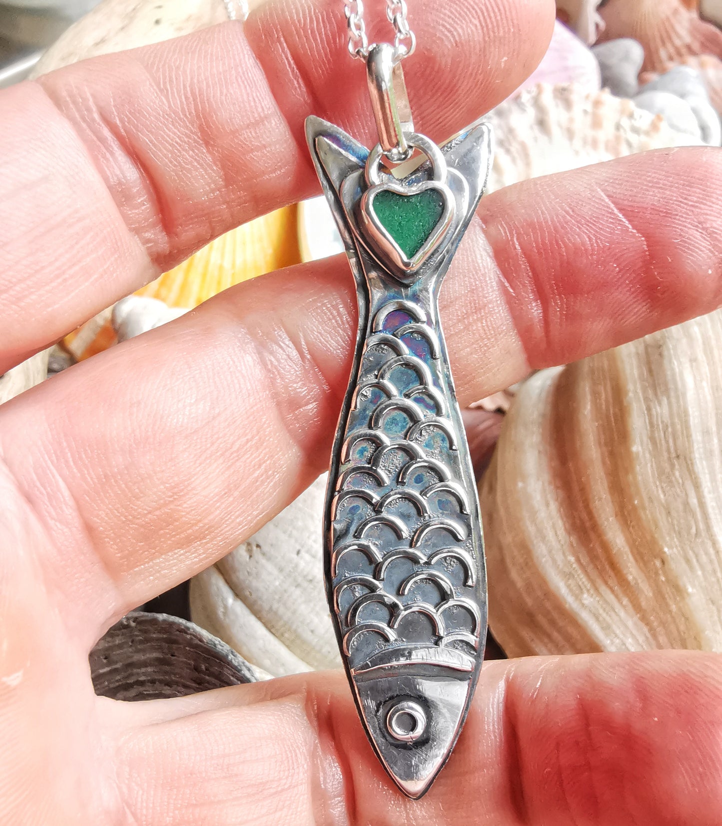Silver fish pendant with sea glass heart detail.