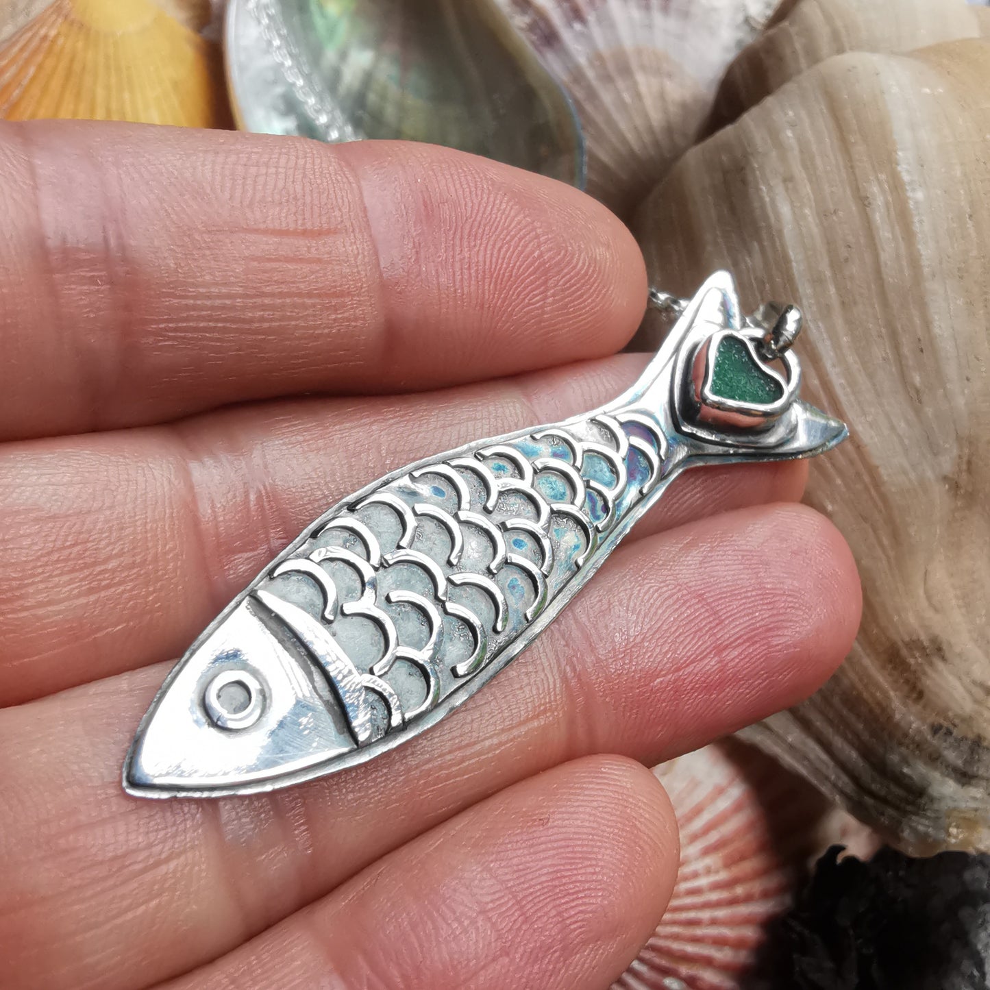 Silver fish pendant with sea glass heart detail.