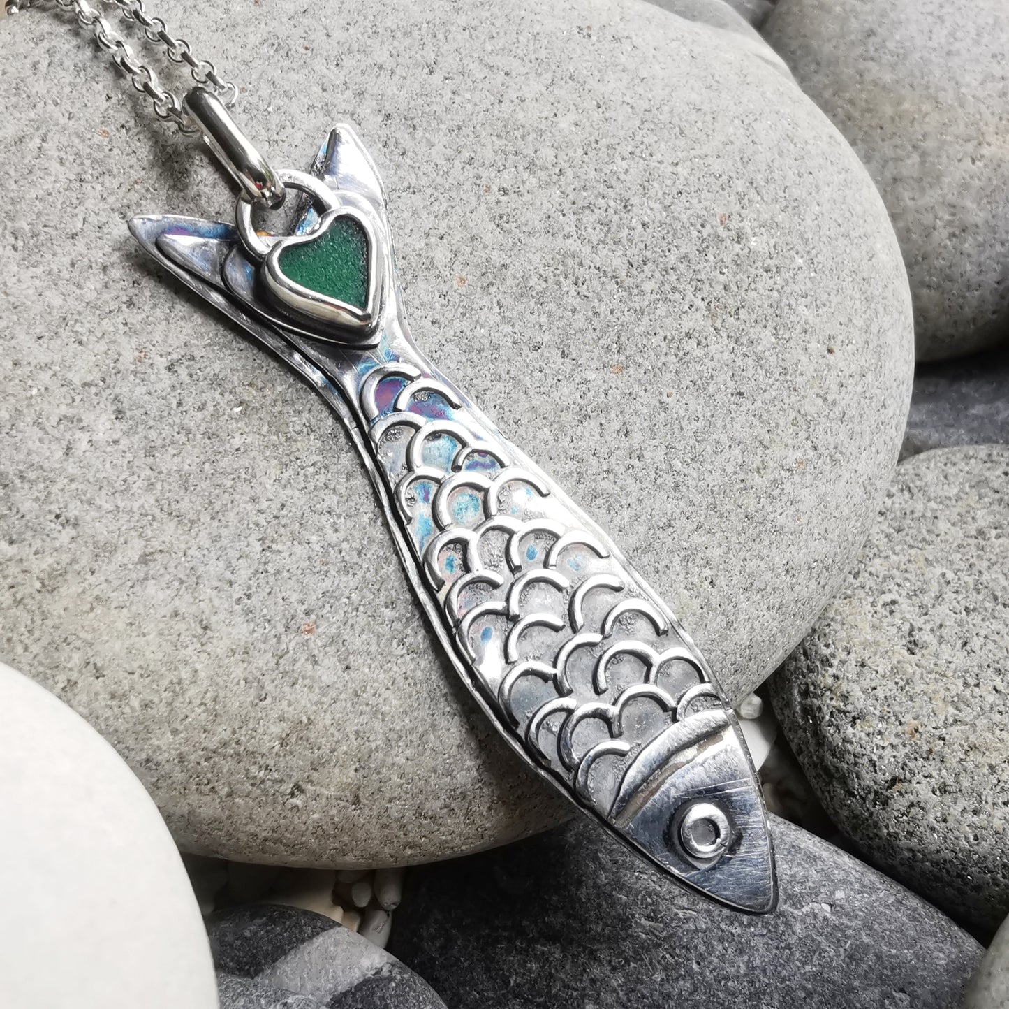 Silver fish pendant with sea glass heart detail.