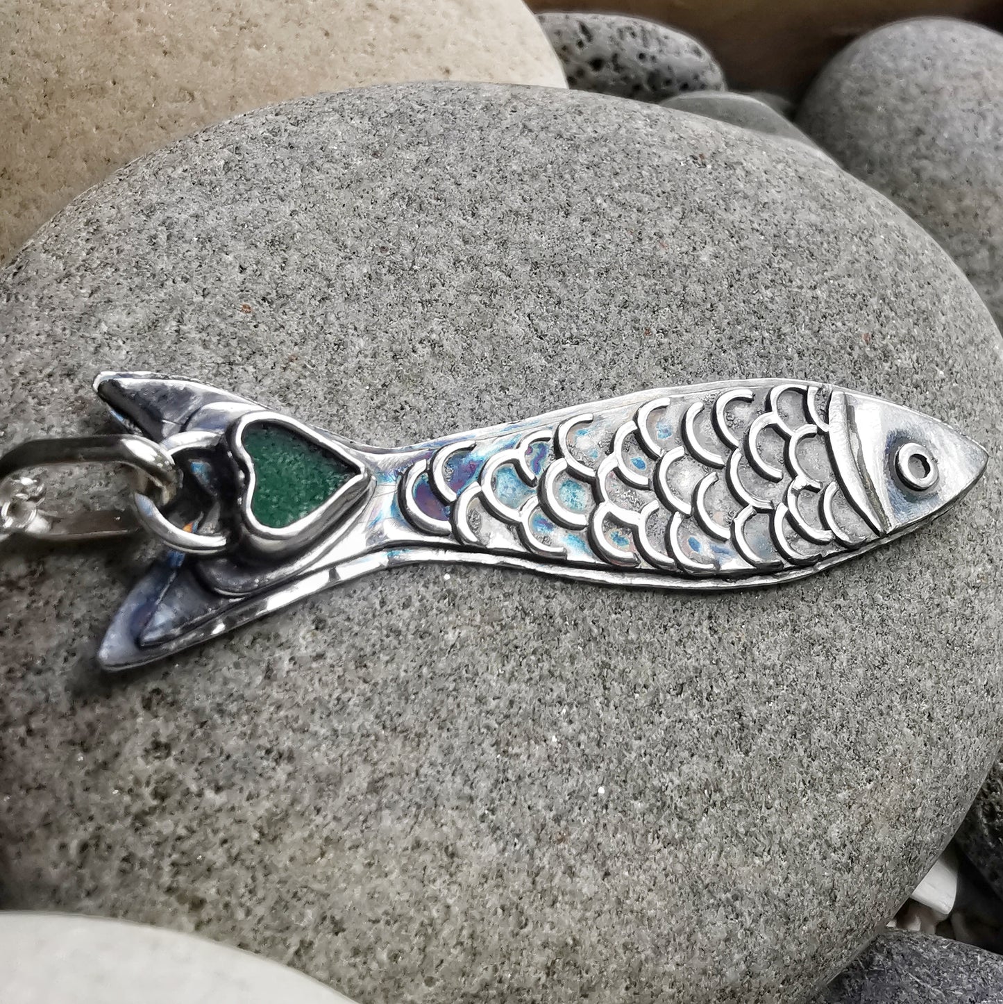 Silver fish pendant with sea glass heart detail.