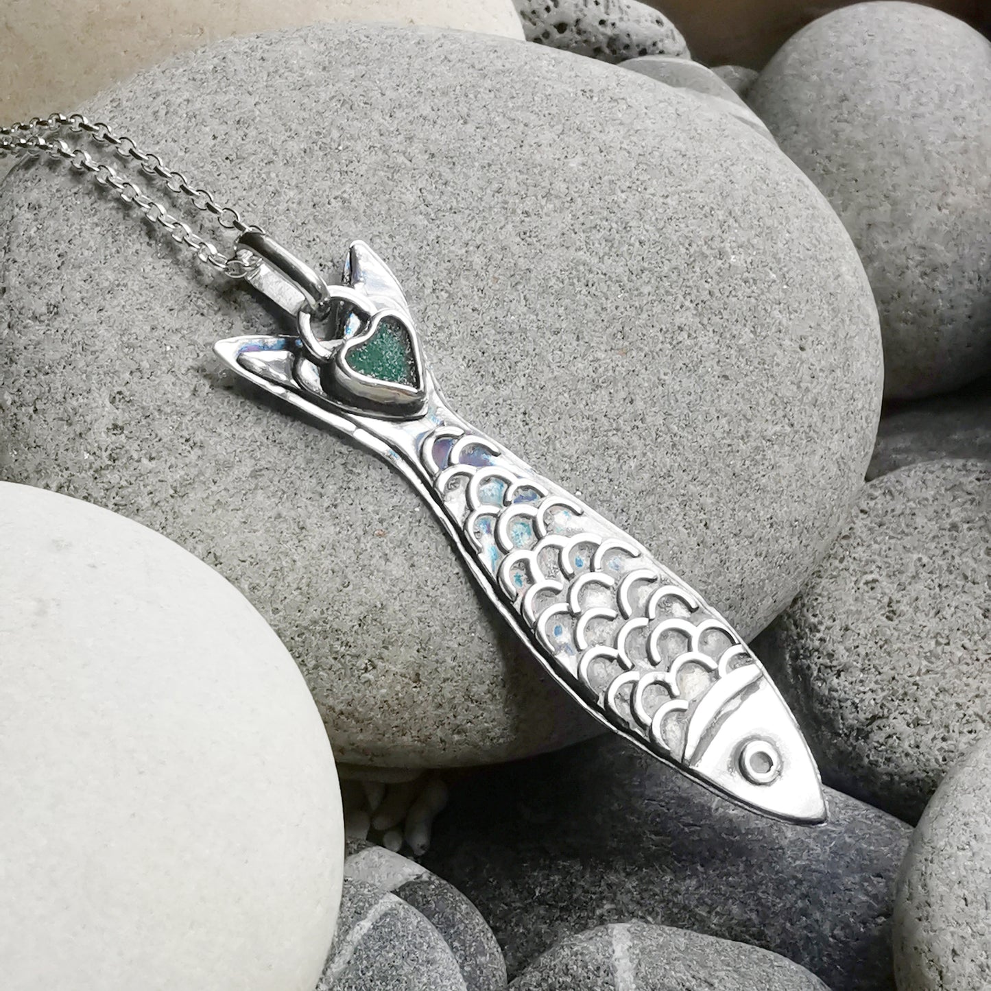 Silver fish pendant with sea glass heart detail.