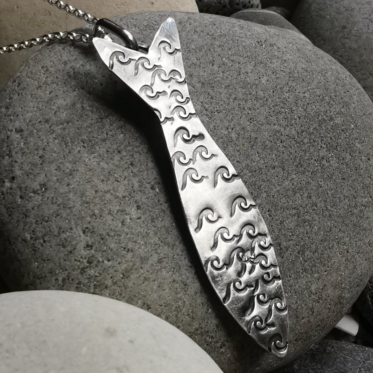 Silver fish pendant with sea glass heart detail.