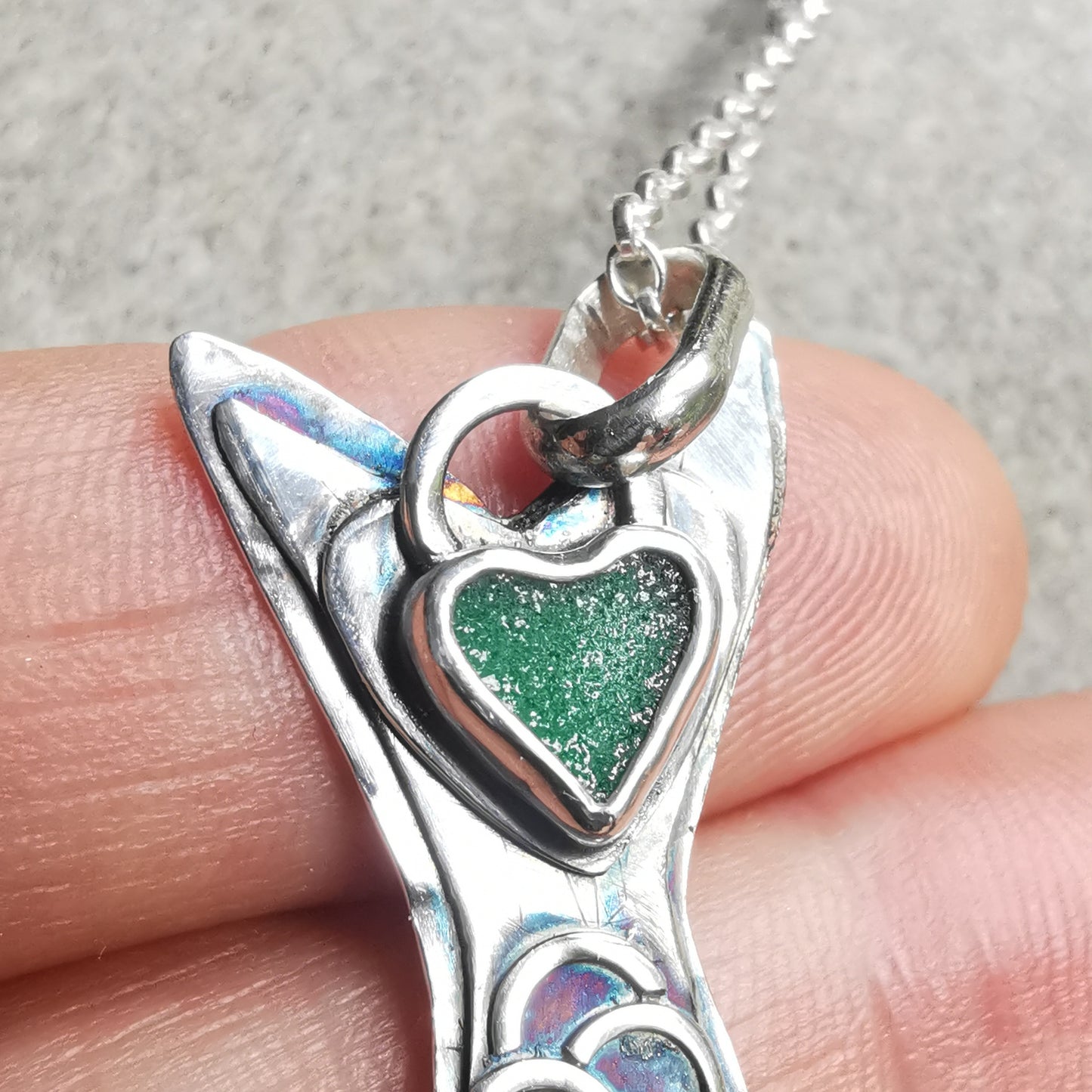 Silver fish pendant with sea glass heart detail.