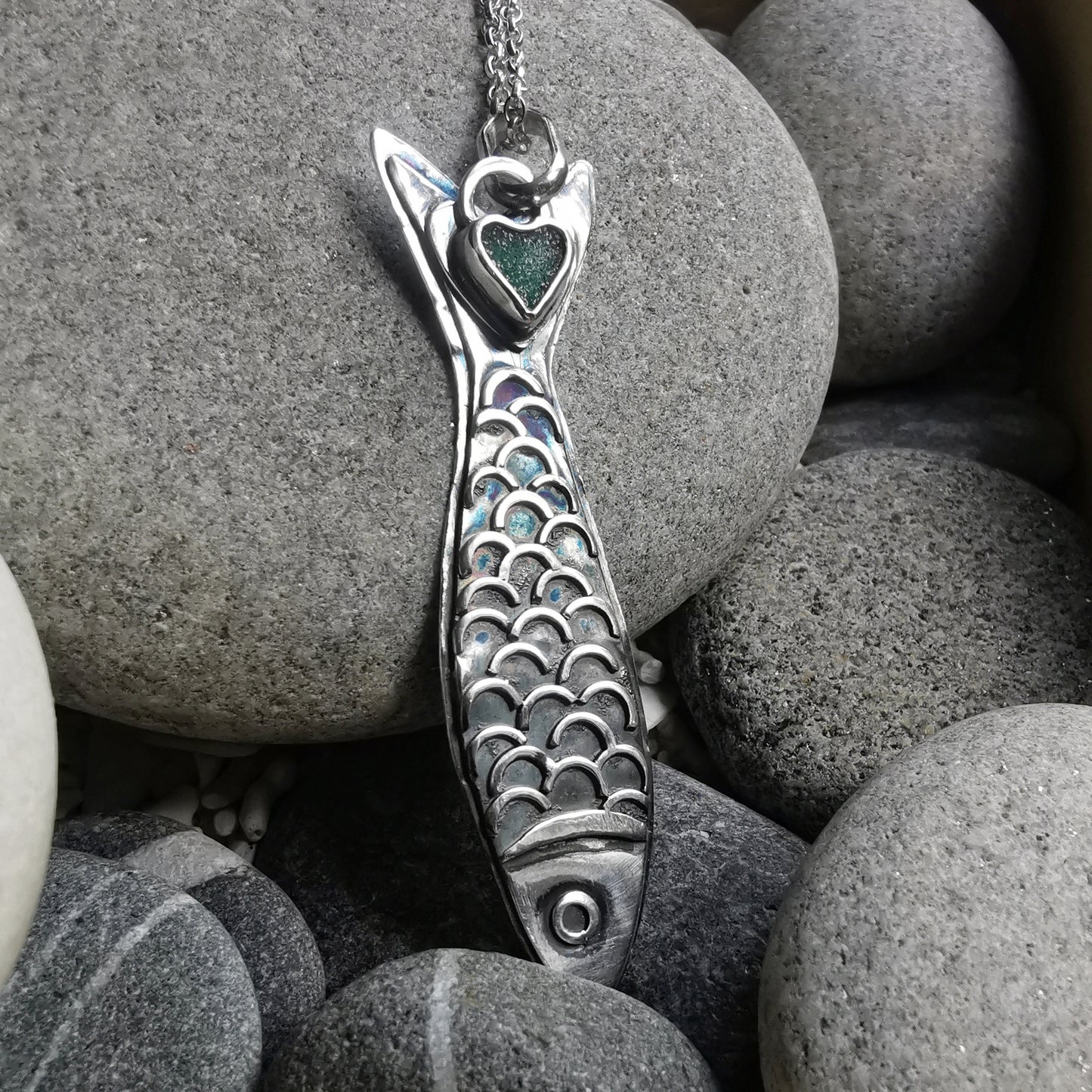 Silver fish pendant with sea glass heart detail.