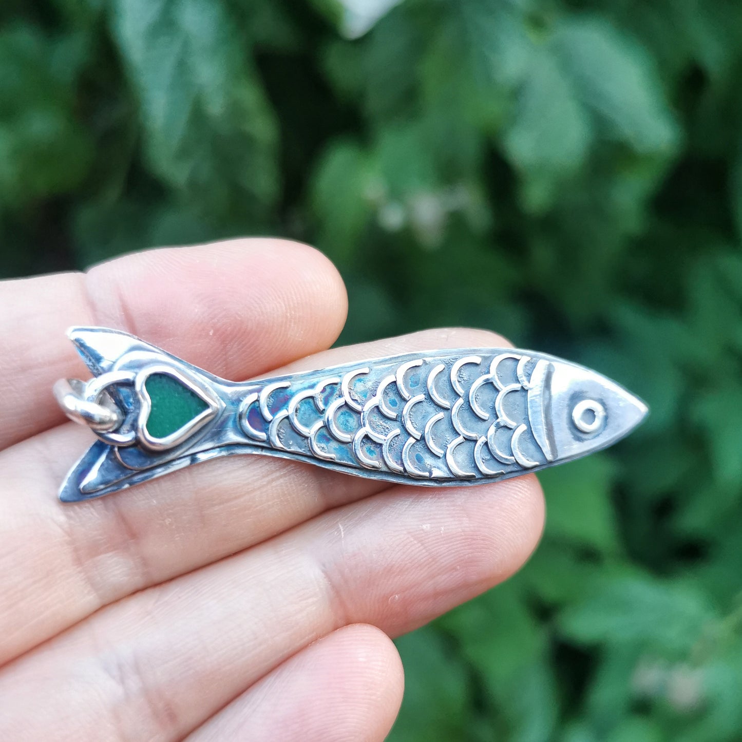 Silver fish pendant with sea glass heart detail.