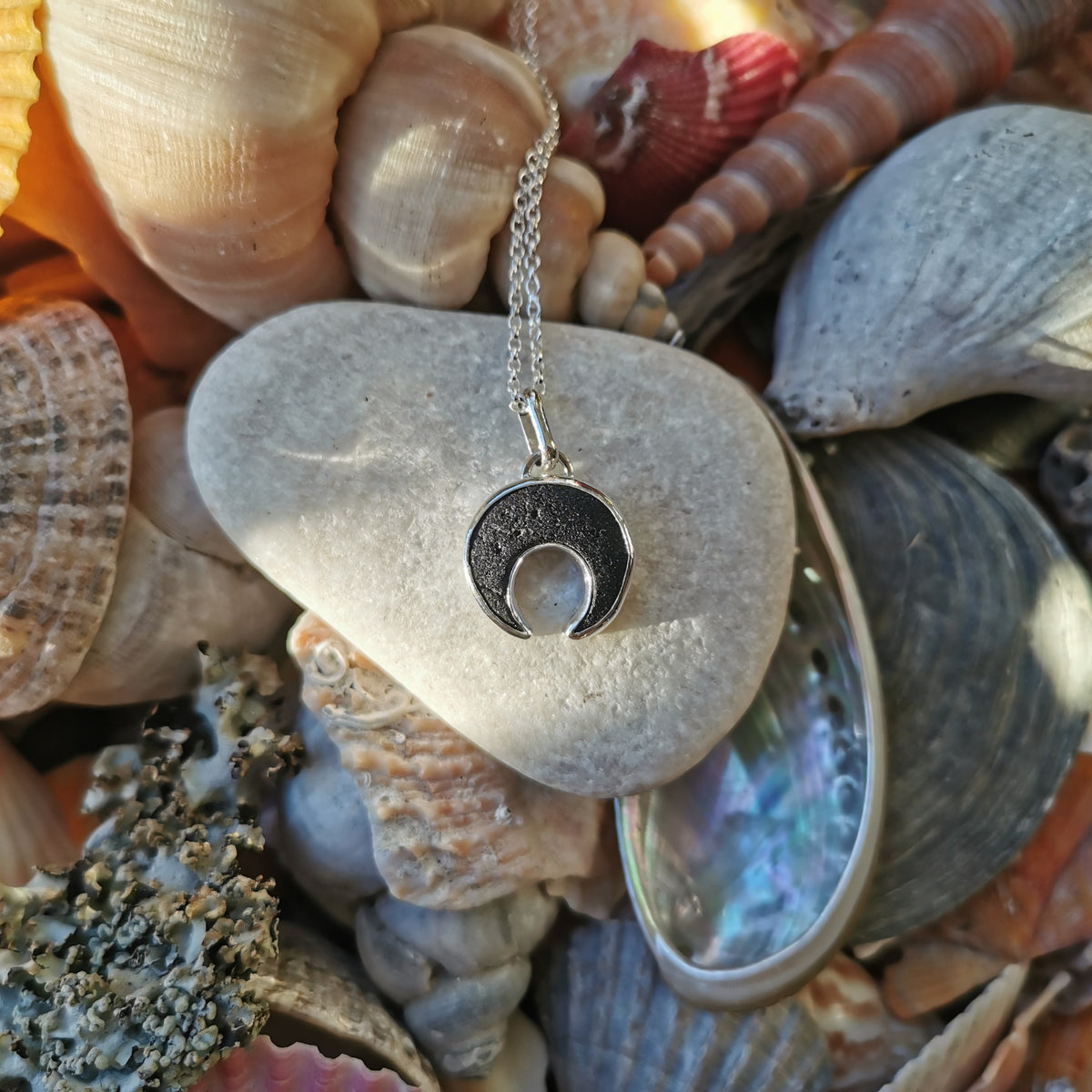 Scottish black sea glass inverted crescent & sterling silver pendant.
