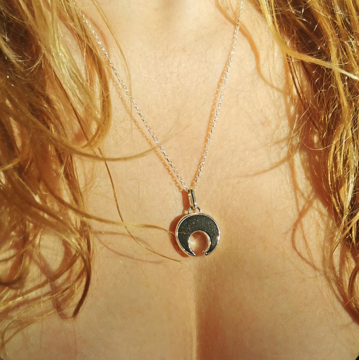 Scottish black sea glass inverted crescent & sterling silver pendant.